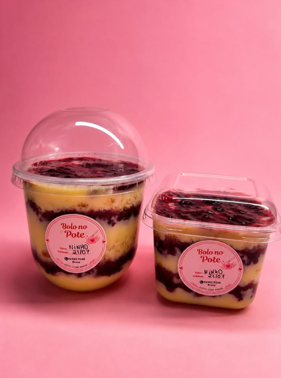 Dois bolos no pote com camadas de creme e geleia de frutos vermelhos sobre fundo rosa